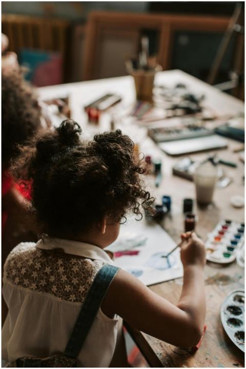 A child painting with watercolors at an indoor art