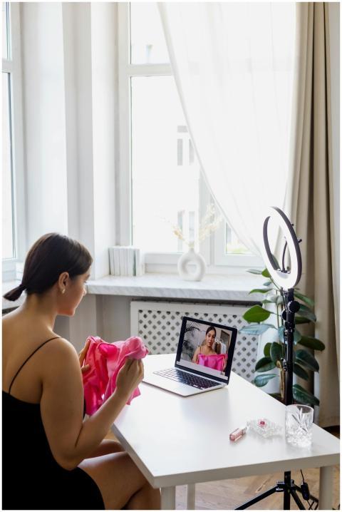 A young woman creates fashion vlog content at home