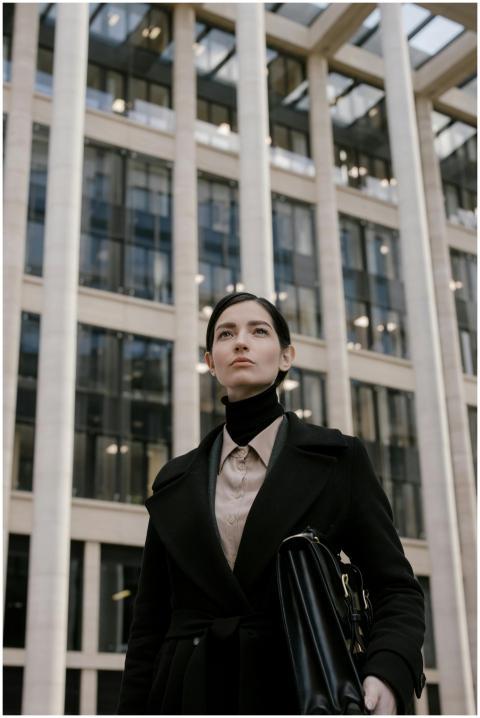 Professional woman in black coat standing in front