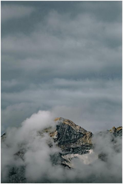 A rugged mountain peak shrouded in mist and clouds