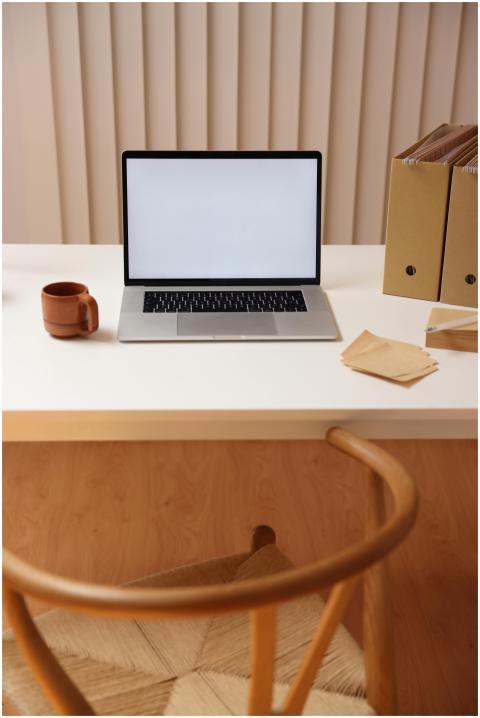 Simple workspace setup with open laptop, coffee cu