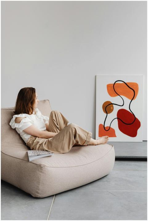 A woman sitting on a bean bag, gazing at a colorfu