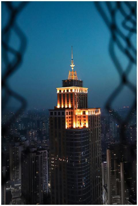 A striking view of a lit skyscraper in a bustling