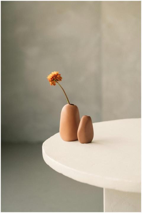 Simple ceramic vases with a single orange flower o