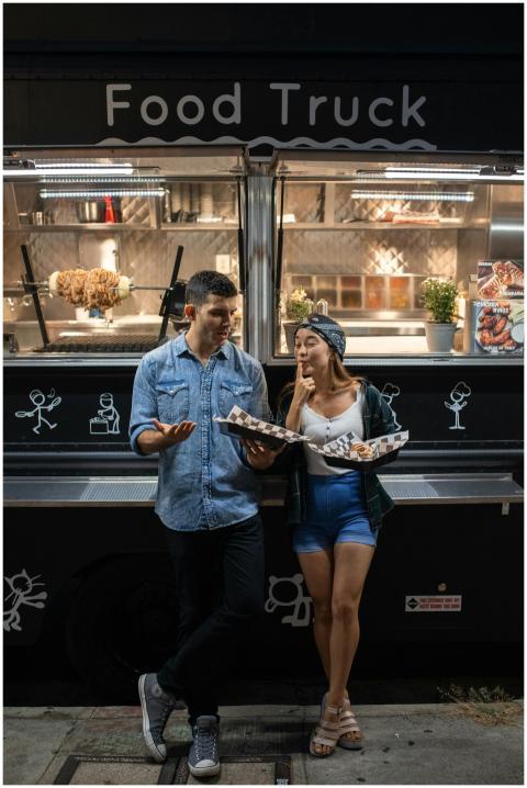 Urban couple savoring meals at night by a trendy f