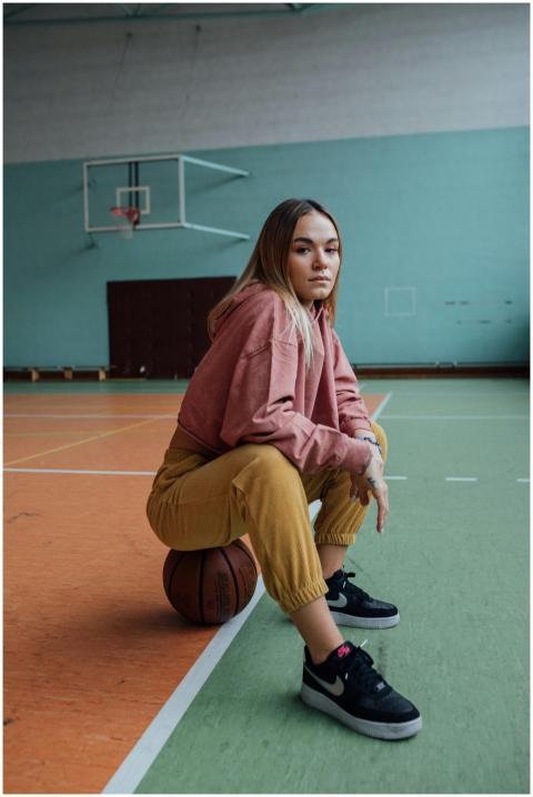 Stylish woman in casual attire sitting on a basket