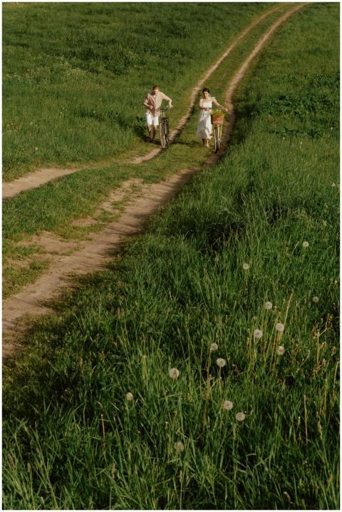 A couple enjoys a leisurely bike ride on a grassy