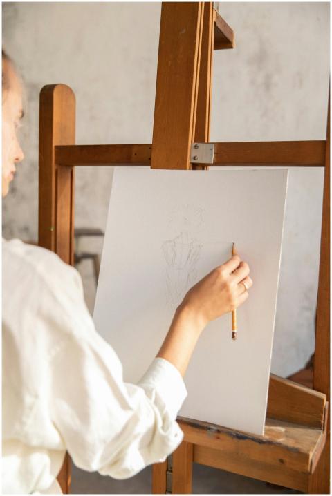 A woman sketching on a canvas with a pencil in an