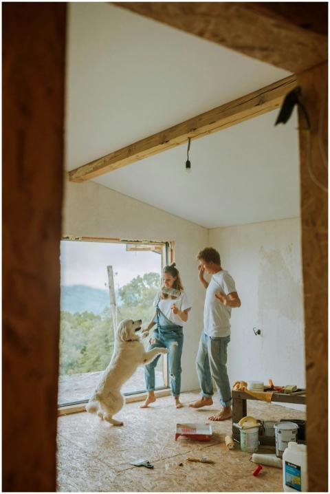 Happy couple and dog renovating their home, enjoyi