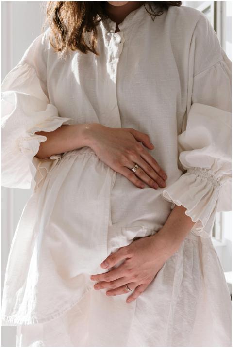 A serene image of a pregnant woman wearing a white