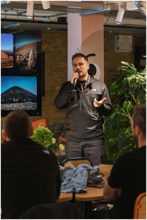 A man presenting to a seated audience with visuals