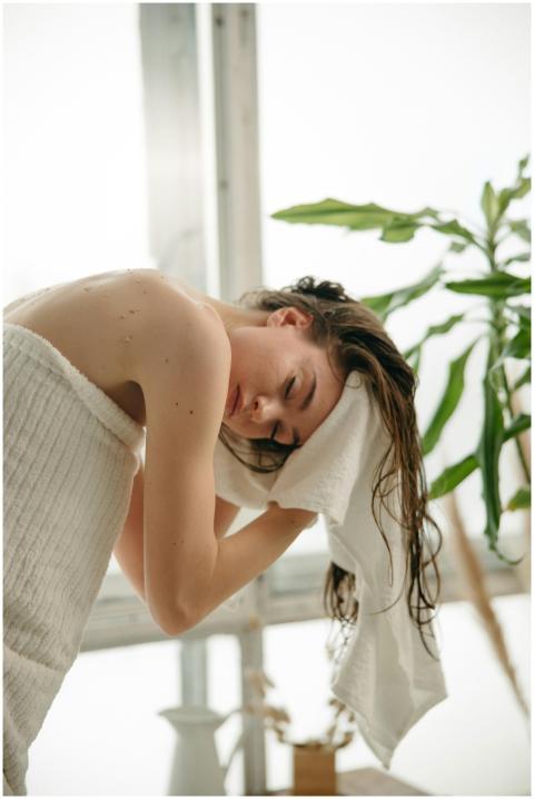 Relaxed woman drying her hair with a towel indoors