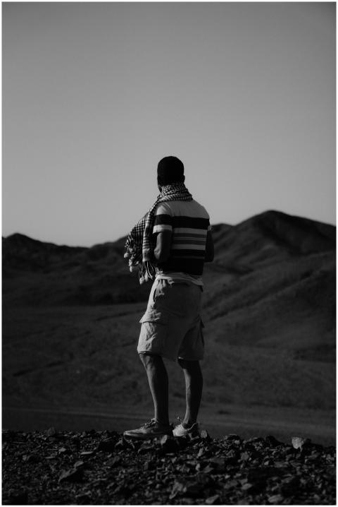 Black and white photo of a man standing in the des