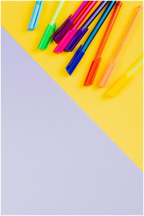 Vibrant colored pens arranged creatively on a yell