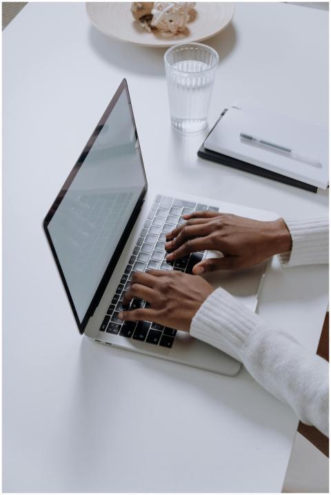 A woman typing on a laptop at a minimalist, modern