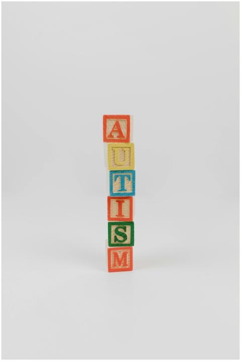 Vertical stack of colorful wooden blocks spelling