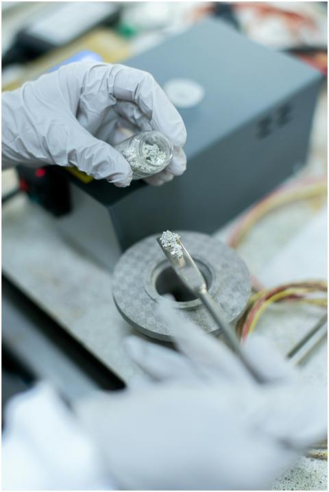 Close-up of a scientist handling metal samples in