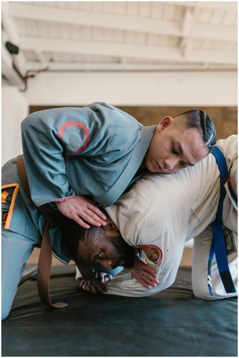 Two martial artists practice grappling techniques