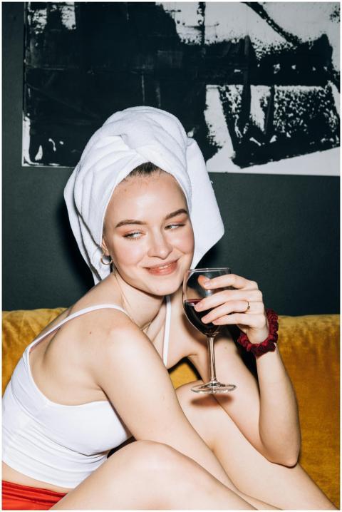 Young woman in towel and casual wear relaxing with