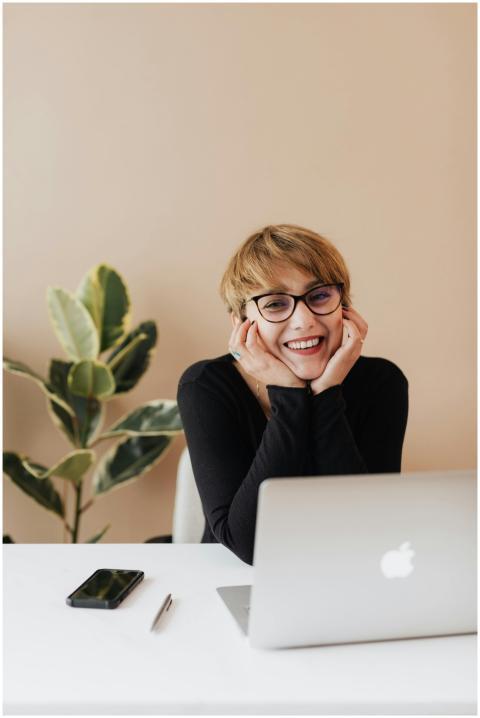 Cheerful woman in eyeglasses and black sweater smi