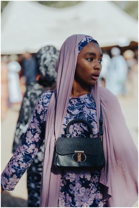 Young woman in purple traditional attire, with a b
