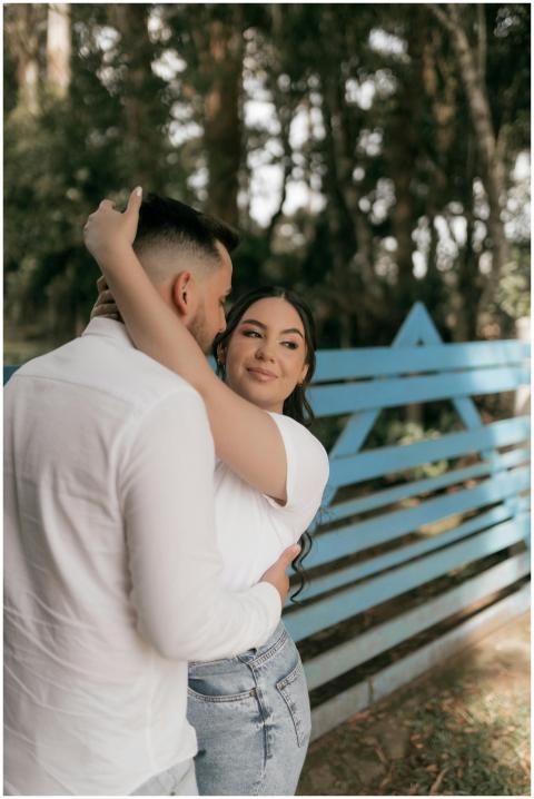 Young couple in a loving embrace by a blue fence i