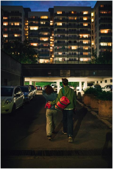 A couple walking together along a dimly-lit urban