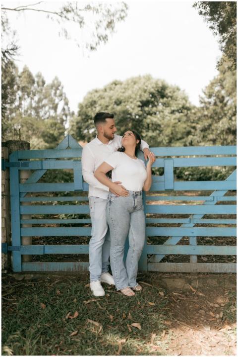 Happy couple in white shirts and jeans posing by a