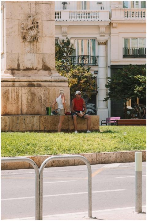 A man and a woman relax by a monument in a sunny V