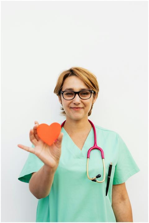Smiling healthcare professional holding a heart sy