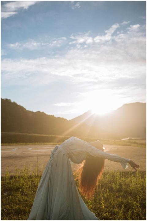 A woman in a flowing dress gracefully dances outdo
