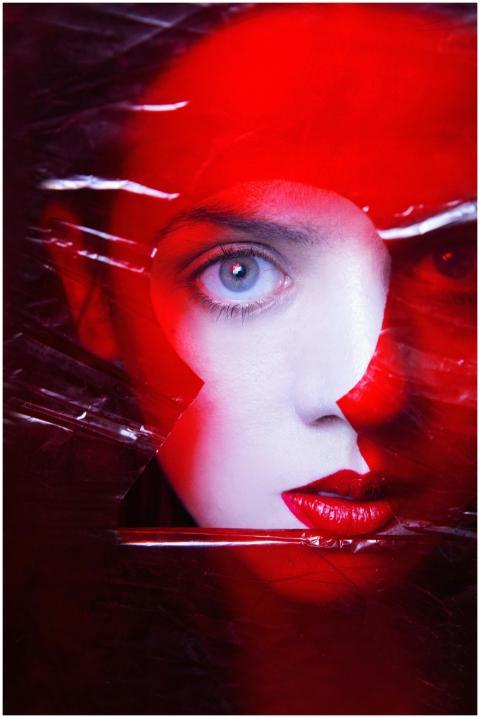 Artistic portrait of a woman with vivid red hues a