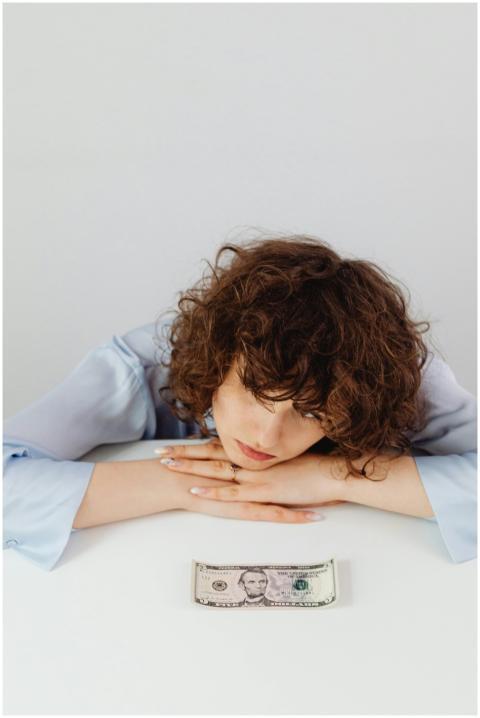 Woman with curly hair rests her head on a table ga