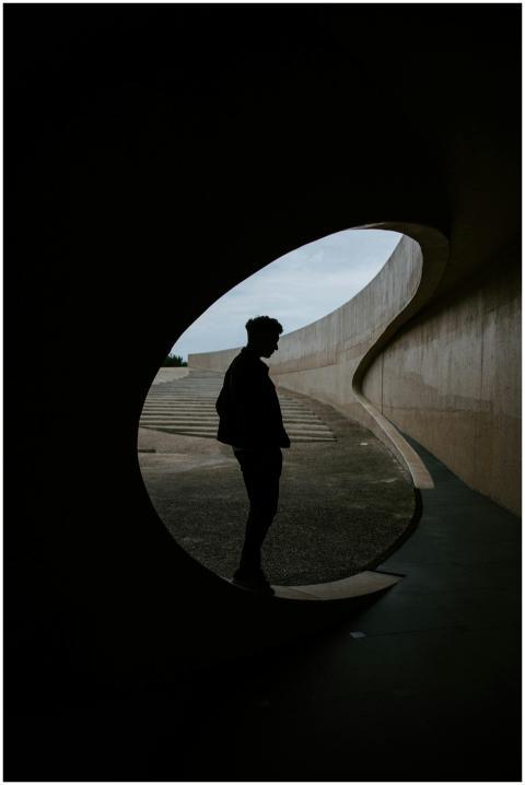 Silhouette of a man standing in a uniquely curved