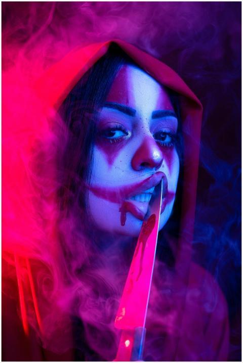Portrait of a woman in Halloween makeup with a kni