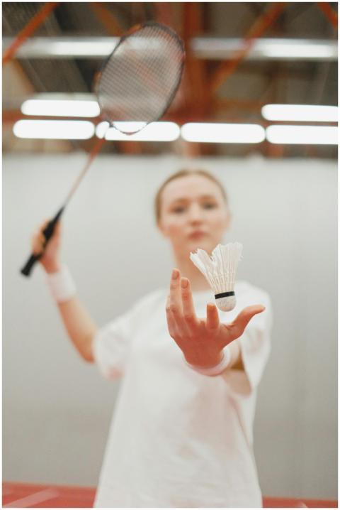 A young female badminton player holding a shuttlec