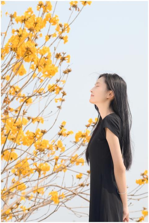 A woman enjoys a peaceful moment beside vibrant ye