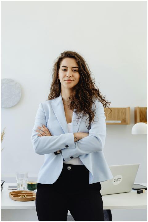 Professional woman in a white blazer standing conf