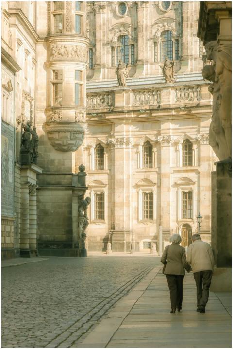 An elderly couple walking together in historic Dre