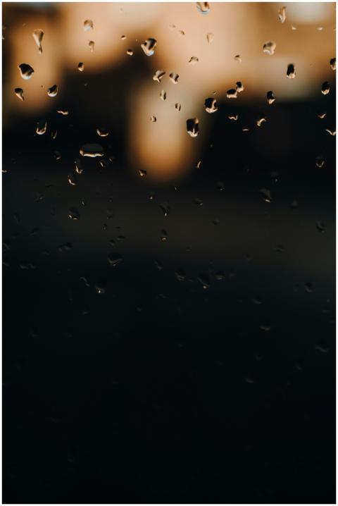Blurred raindrops on a window with soft evening li