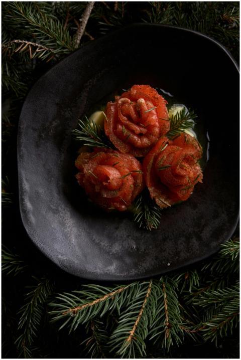 Artistic presentation of salmon roses on a black p