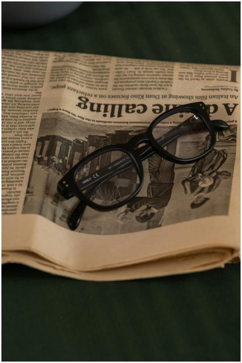 Black rimmed glasses resting on top of a newspaper