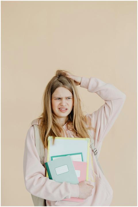 Teenage girl on beige backdrop holding colorful no