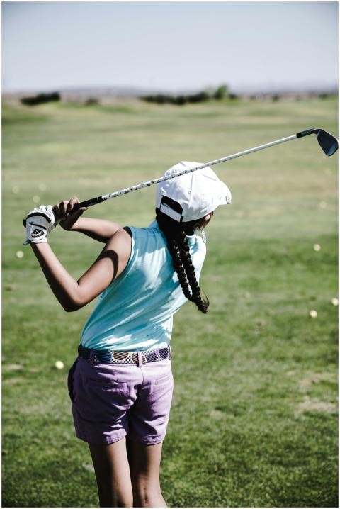 Girl practicing golf swing on a sunny day at the g