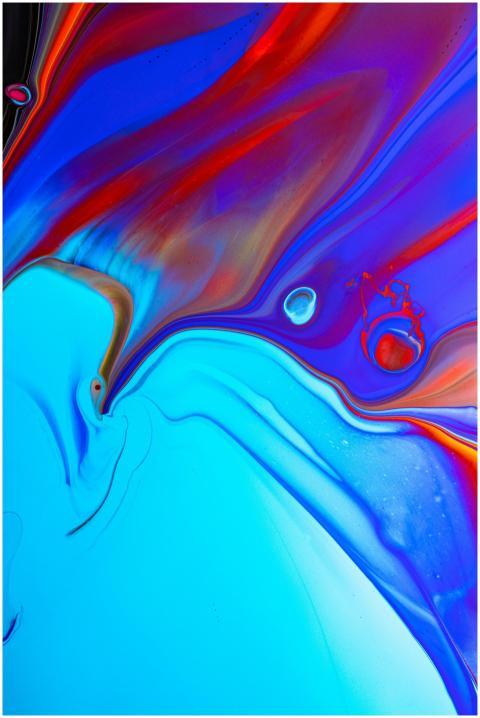 From above of colorful iridescent paints flowing a