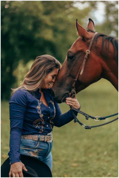A woman happily bonding with her horse in a green