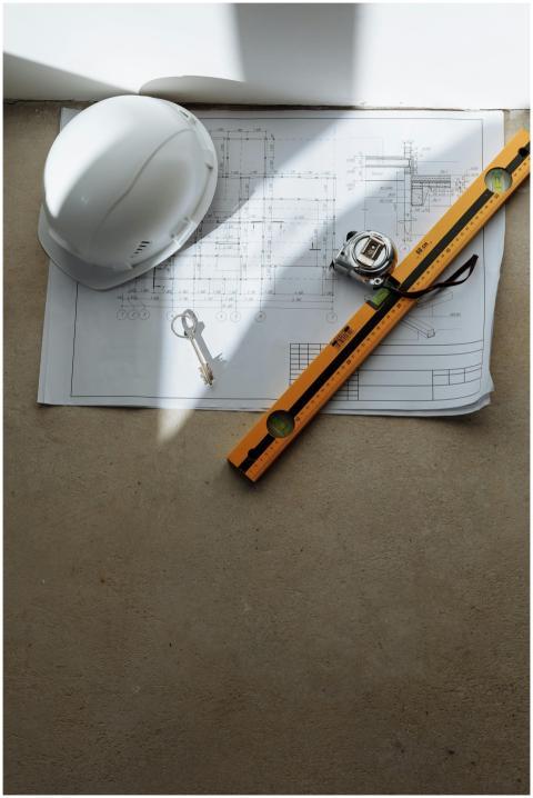 Top view of architectural blueprint with helmet an