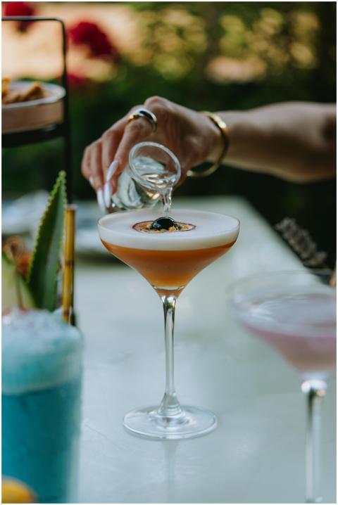 Detailed shot of liquor being poured into a cockta