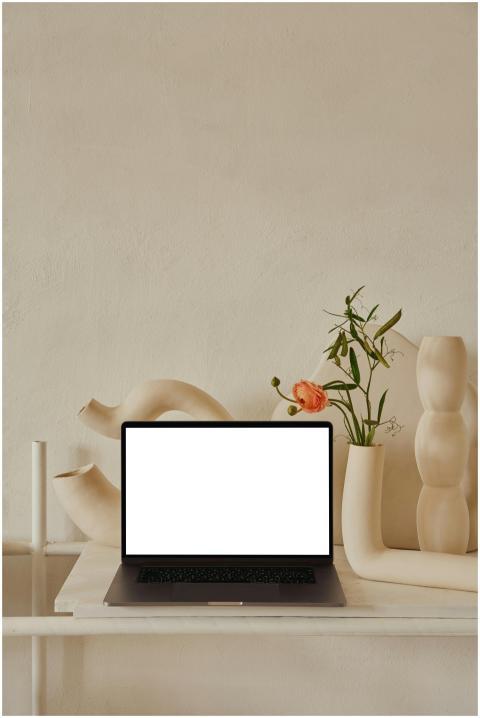 Netbook with white screen placed on shelf near une