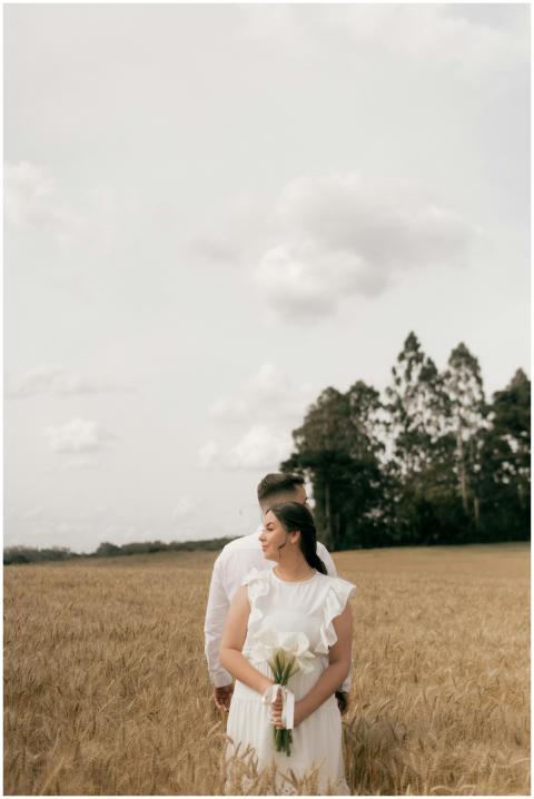 A couple in love stands together in a golden wheat